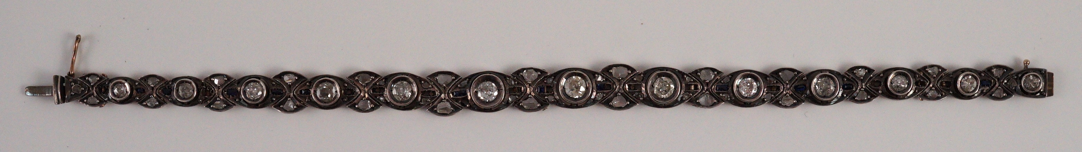An early to mid 20th century continental gold and silver, graduated diamond and sapphire set line bracelet